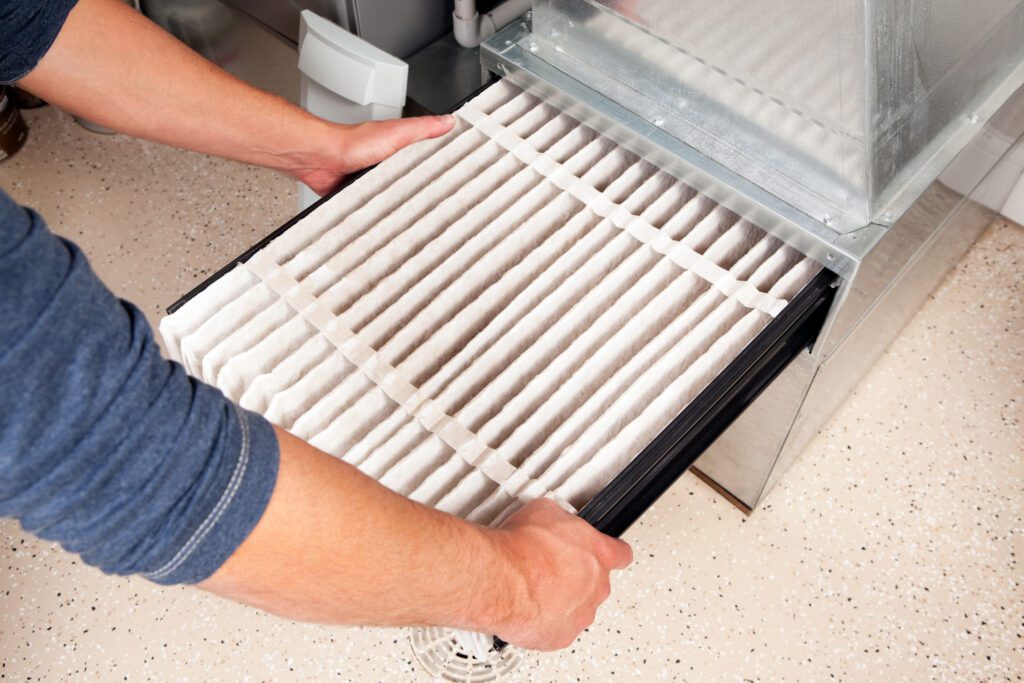 a new dry furnace filter being installed in a furnace