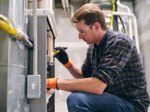 furnace repairman troubleshooting the furnace's ignitor